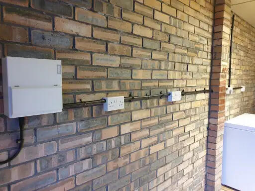 Outbuilding wiring on a brick wall